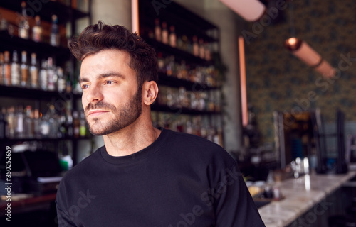 Portrait Of Confident Male Owner Of Restaurant Bar Standing By Counter © Monkey Business