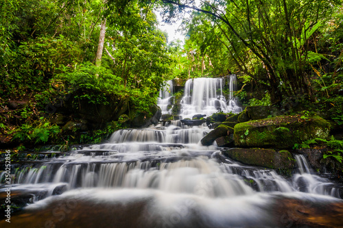 Fototapeta Naklejka Na Ścianę i Meble -  Beautiful nature rock waterfall steps. Waterfall in mountain valley with tropical rainforest at Mun Dang Waterfall, Phu Hin Rong Kla National Park, Phetchabun, Thailand.