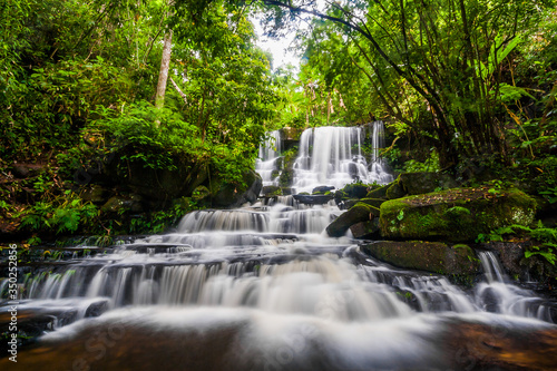 Beautiful nature rock waterfall steps. Waterfall in mountain valley with tropical rainforest at Mun Dang Waterfall, Phu Hin Rong Kla National Park, Phetchabun, Thailand.