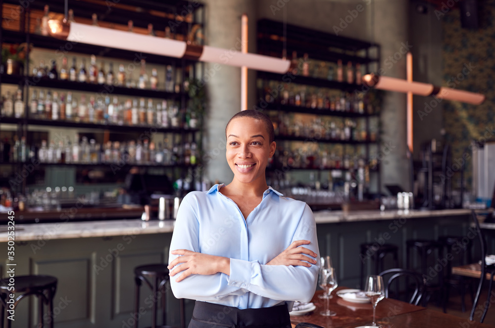 Portrait Of Confident Female Owner Of Restaurant Bar Standing By Counter