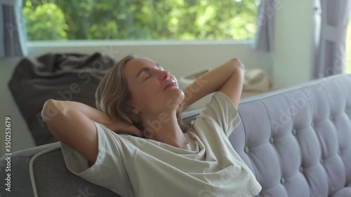 Girl closed hands behind hand breathing fresh air resting in comfortable sofa at home Calm young woman dozing daytime nap on couch with closed eyes
