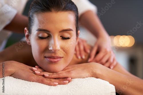Relaxed woman receiving back massage