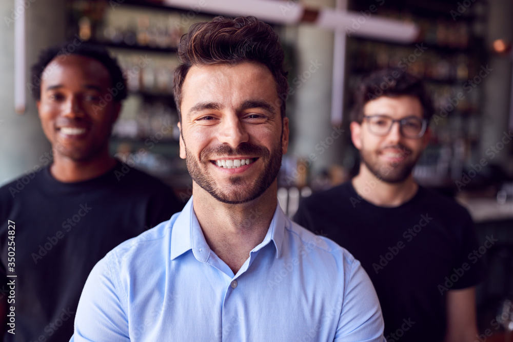 Portrait Of Male Owner Of Restaurant Bar With Team Of Waiting Staff Standing By Counter Portrait Of Male Owner Of Restaurant Bar With Team Of Waiting Staff Standing By Counter