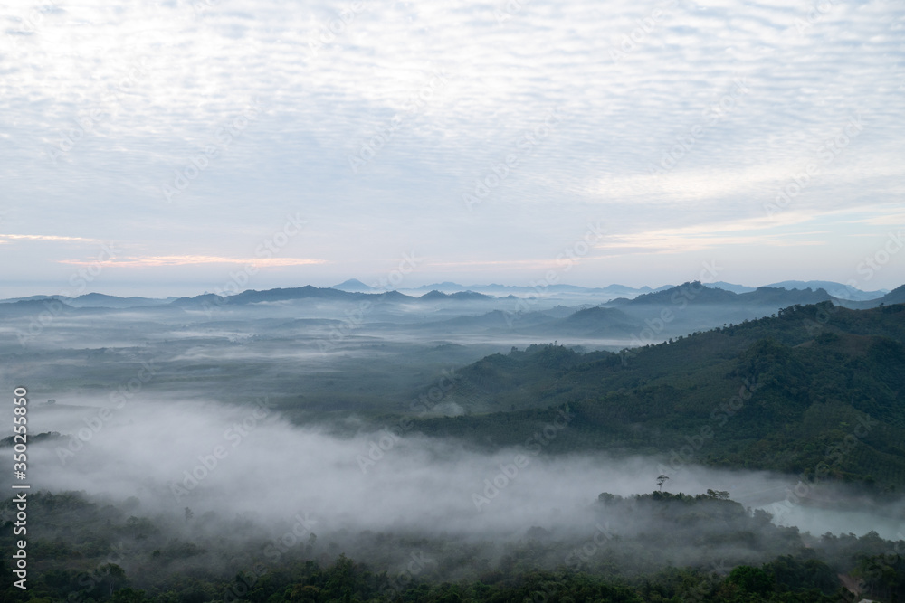 Nature scenery view of misty mountain with fog in summer morning and cloudy sky Nature scenery view of misty mountain with fog in summer morning and cloudy sky