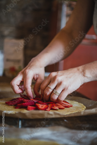 Une femme prépare une tarte aux fraises sur une table en bois photo