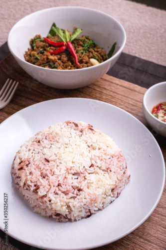 Stir fried minced pork with basil served with steamed jasmin rice and Riceberry, Pad kra pao.