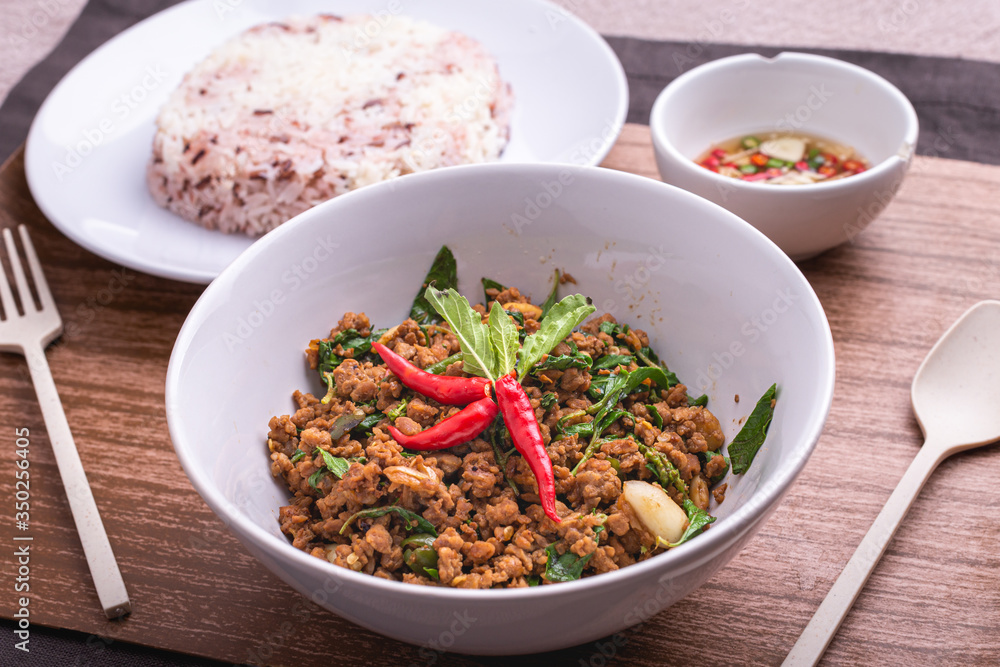 Stir fried minced pork with basil served with steamed jasmin rice and Riceberry, Pad kra pao.