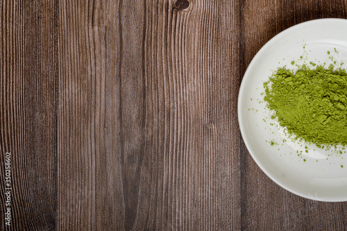 matcha green tea powder in bowl with wood spoon on wooden table. Top view. Space for text. healthy food concept