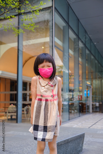 Asian child wearing mask in city street