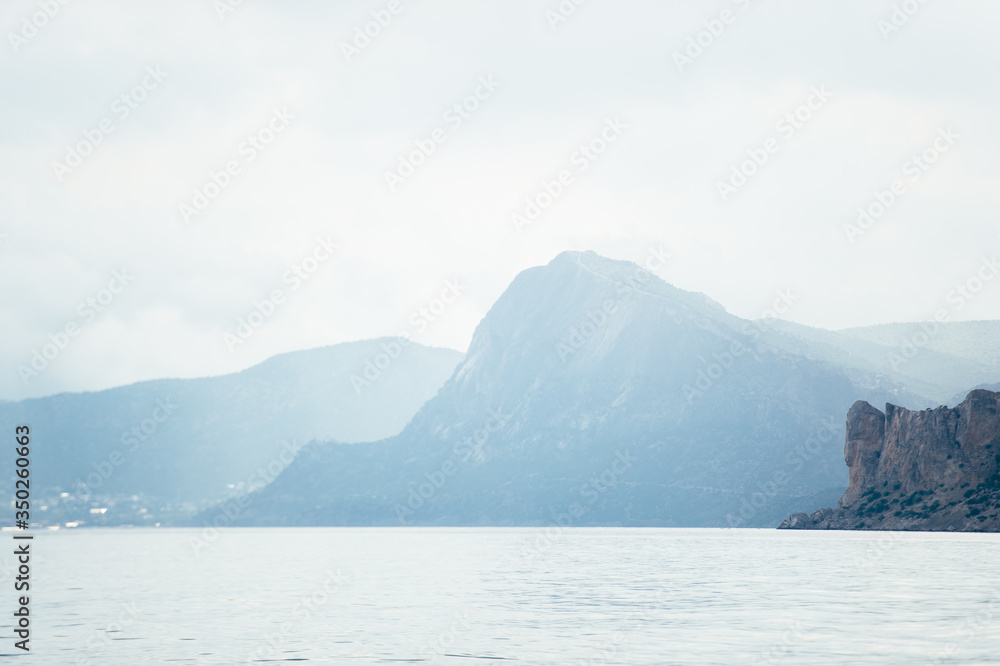 Landscape sea and mountains in the fog