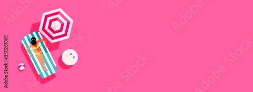 Summer concept of a young girl sunbathes on a deck chair on a sunny day with copyspace on pink background, top view, flat lay. Minimal style
