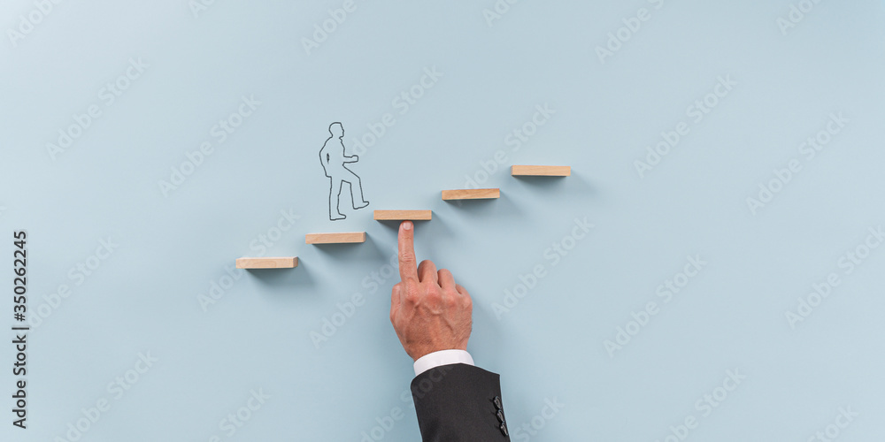 Hand of a businessman supporting wooden step for a silhouetted man to walk upwards - obrazy, fototapety, plakaty 