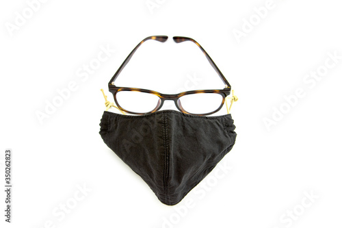 The front of the black cloth mask and glasses were arranged to resemble a man's face. Concept of anti-virus spread.white background and copy space.
