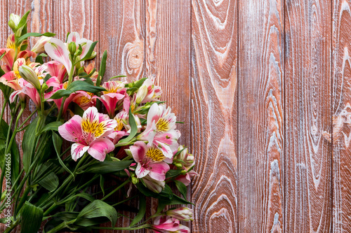 Alstroemeria on the wooden background. flowers on a brown background. copy text. beautiful bouquet.