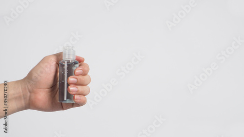 Hands is holding alcohol hand gel on white background.