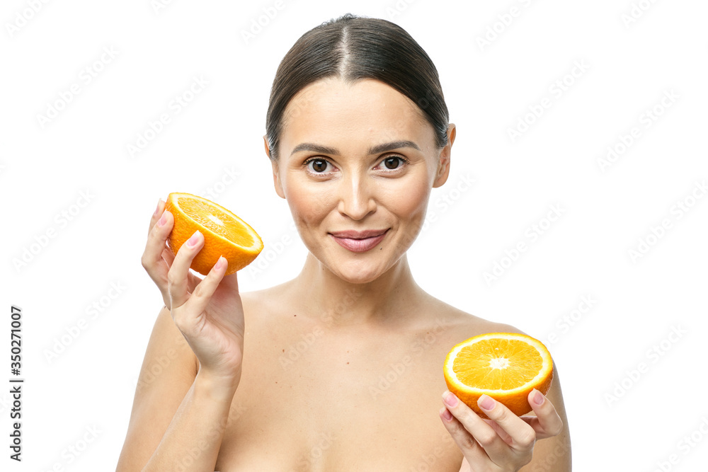 close-up portrait of a young girl with clear skin, holding an orange on a white background close-up portrait of a young girl with clear skin, holding an orange on a white background