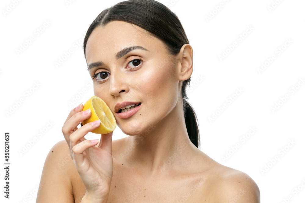 close-up portrait of a girl with clear skin holding a lemon fruit to her face, isolated on a white background close-up portrait of a girl with clear skin holding a lemon fruit to her face, isolated on a white background