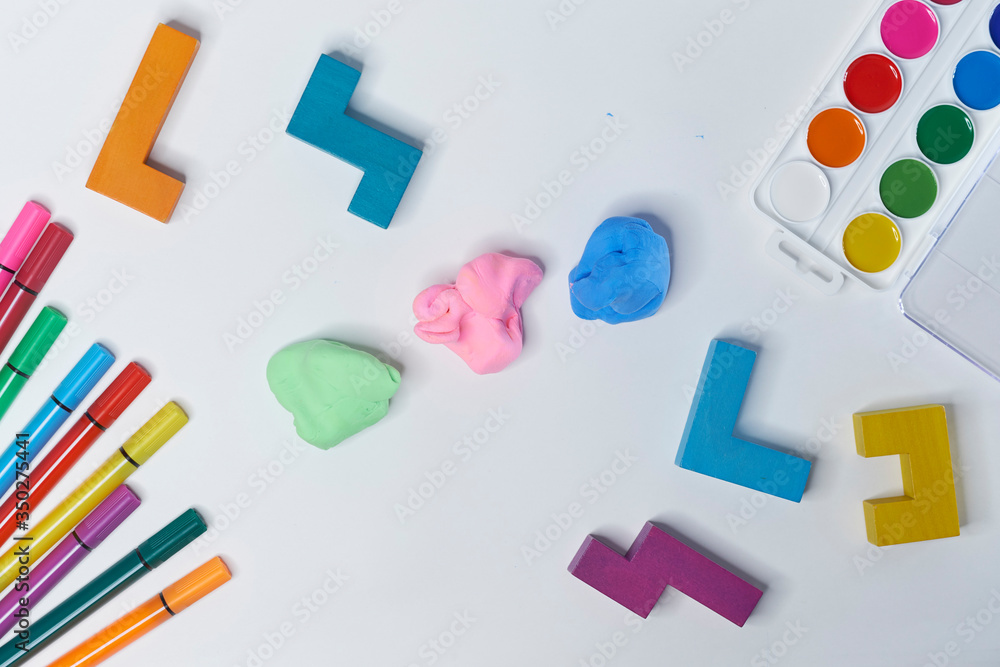 felt-tip pens, cubes, paints and plasticine on a white background. children's desktop. School, education and learning concept. creativity for kids. Top view colorful background. Flat lay felt-tip pens, cubes, paints and plasticine on a white background. children's desktop. School, education and learning concept. creativity for kids. Top view colorful background. Flat lay
