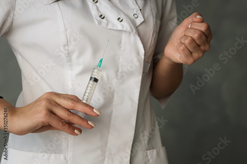 syringe in the hands of a nurse in a white coat