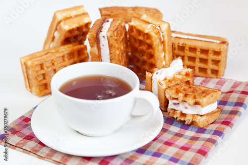 Belgian waffles and tea in a mug on the table.