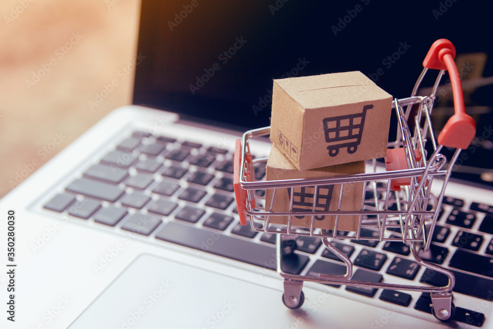 Shopping online. cardboard box with a shopping cart logo in a trolley on laptop keyboard. Shopping service on The online web. offers home delivery
