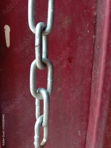 Old padlock chain on the red door