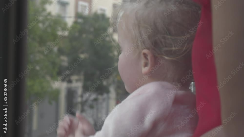 Mom with little daughter looking outside from window during Covid-19 ...