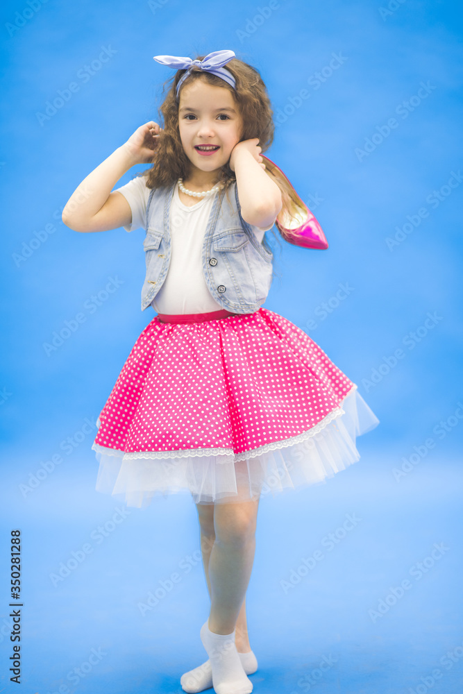 Girl shows her pink polka in dot dress. Girl shows her pink polka in dot dress.