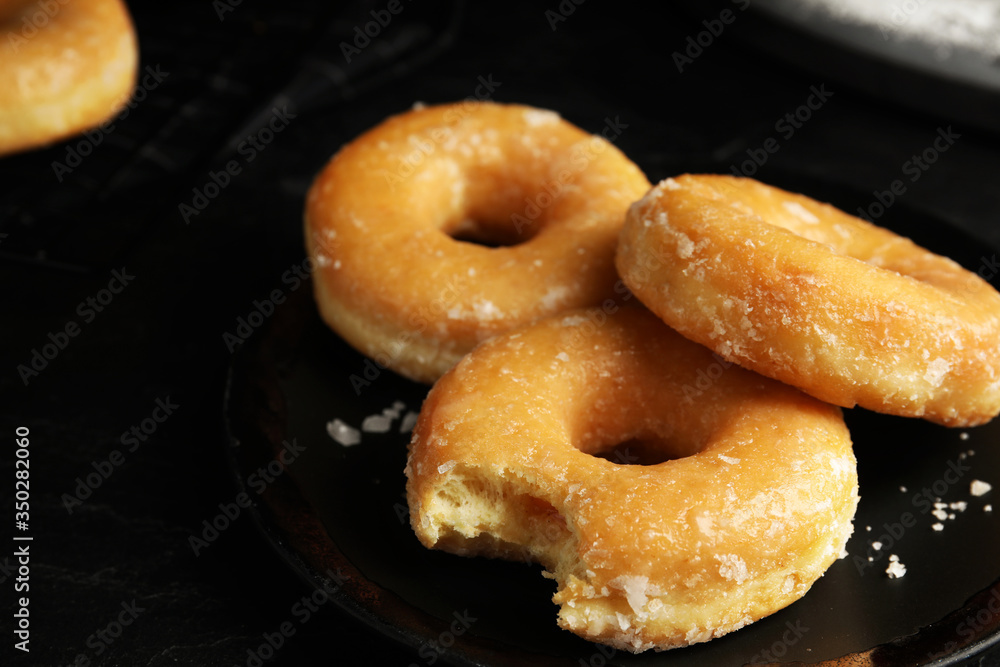 Sweet delicious glazed donuts on black table Sweet delicious glazed donuts on black table