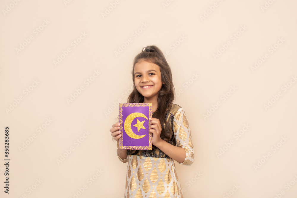 Small girl wearing traditional pakistani dress and celebrating Ramadan Kareem.