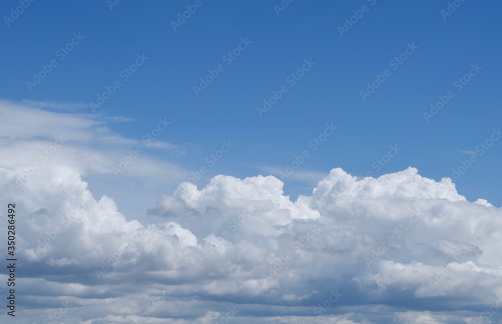 Aerial view on moody thunder clouds flying on horizon under blue sky