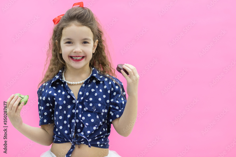 A girl holding two macaroons in hands. A girl holding two macaroons in hands.