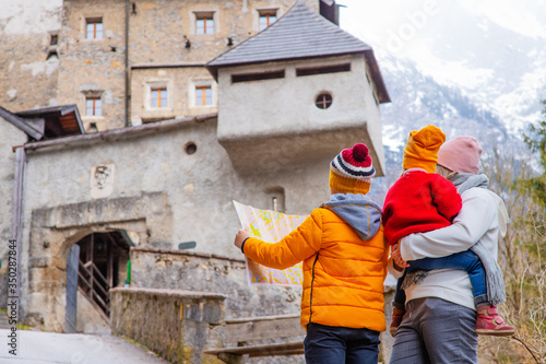 Family with children taking a walk near an ancient castle in Austria