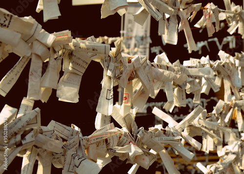 O-mikuji are random fortunes written on strips of paper at Shinto shrines and Buddhist temples in Japan. Hiroshima Gokoku Jinja shinto temple, 02-15-2015 photo