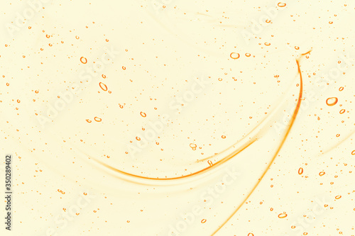 Oil serum texture. Yellow vitamin C, vitamin E liquid gel. Cosmetic cream with bubbles smear smudge. Beauty skincare product macro top view