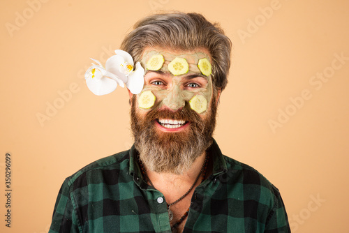 Funny man applied facial masks and cucumbers on face. Funny surprised and crazy comic concept. Facial beauty treatment.