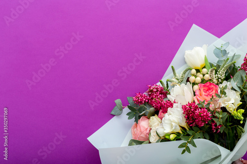 Summer flower bouquet on lilac purple background with place for text. Floristic roses, white tulips composition greeting card for women March 8, Mother Day, Valentine Day, Congratulations concept