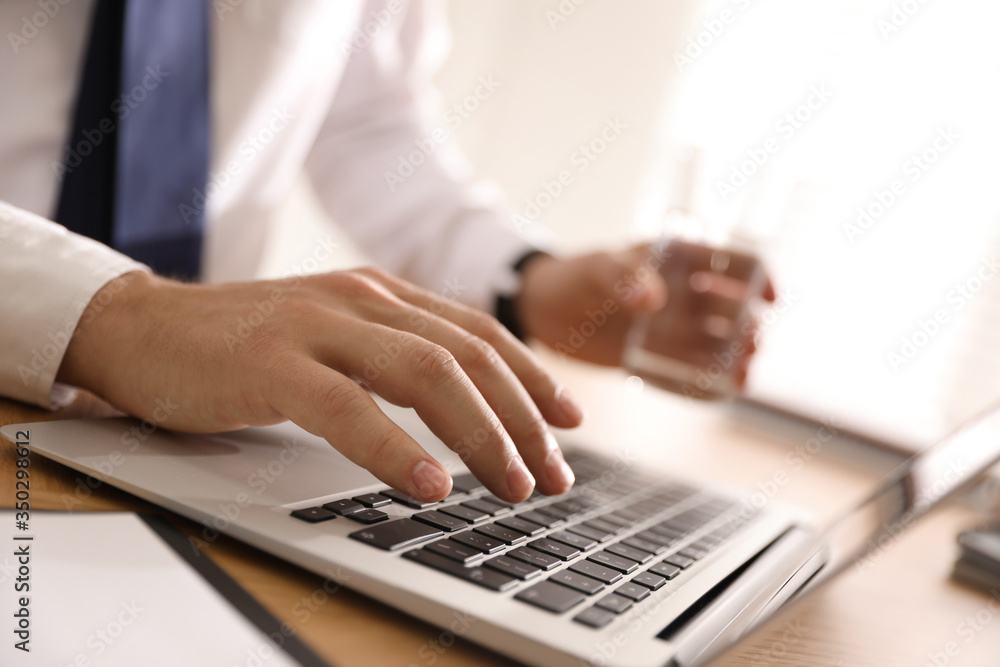 Man working with laptop in office, closeup of hand Man working with laptop in office, closeup of hand
