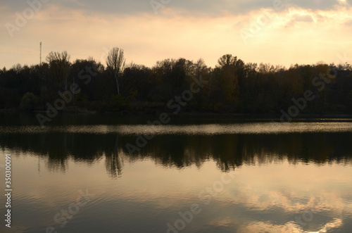 Landscape by the river. Mirror on the water. Water reflection. Boat near the water. The boatman in the fog. The rays of the sun on the water. Ukraine