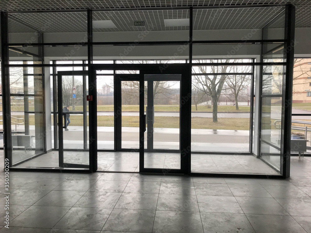 The glass entrance at the entrance to the building store office with sliding double doors The glass entrance at the entrance to the building store office with sliding double doors