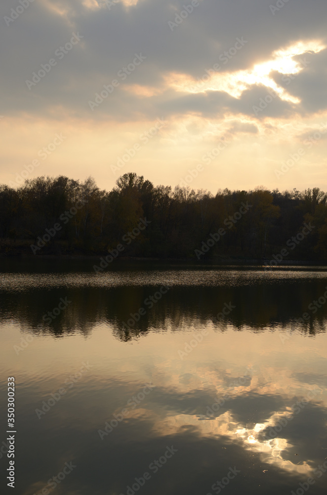 Obraz premium Landscape by the river. Mirror on the water. Water reflection. Boat near the water. The boatman in the fog. The rays of the sun on the water. Ukraine