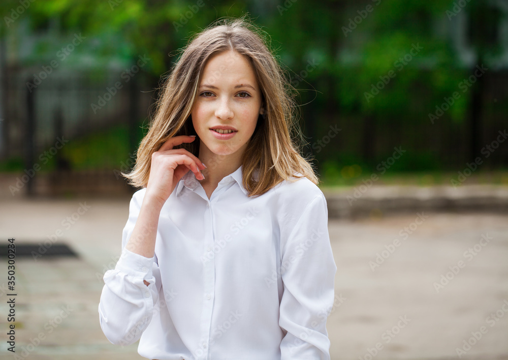 Portrait of a young blonde girl in white shirt and blue jeans Portrait of a young blonde girl in white shirt and blue jeans