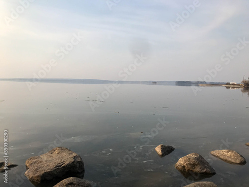 Large round beautiful natural stones cobblestones in water, sea, lake, river. Background, texture