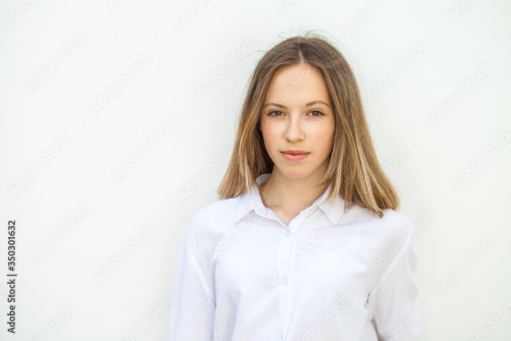 Young blonde girl in white blouse - isolated on white wall background Young blonde girl in white blouse - isolated on white wall background