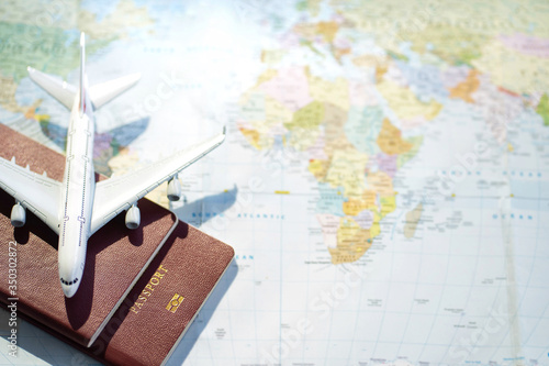 Passport with a map background.Travel planning.Top view of traveler accessories with a plane  on world map.Preparation for travel.Traveling Journey Vacation Holiday concept.