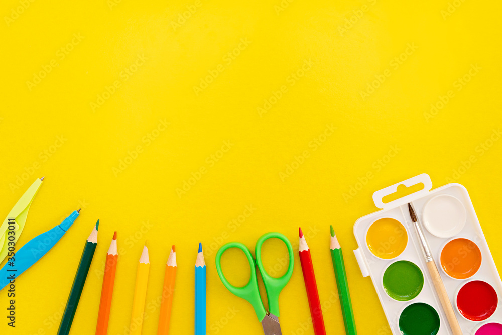 Back to school, creativity and education concept. School supplies, pencils, plasticine, paper clips, notes, stapler, notebook, paints, scissors on a yellow background, flat. Copy space Back to school, creativity and education concept. School supplies, pencils, plasticine, paper clips, notes, stapler, notebook, paints, scissors on a yellow background, flat. Copy space