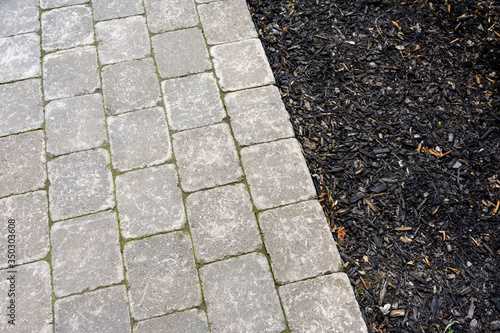 Obraz na plátně Tumbled paver walkway in the garden with mulch create an interesting landscaping abstract background