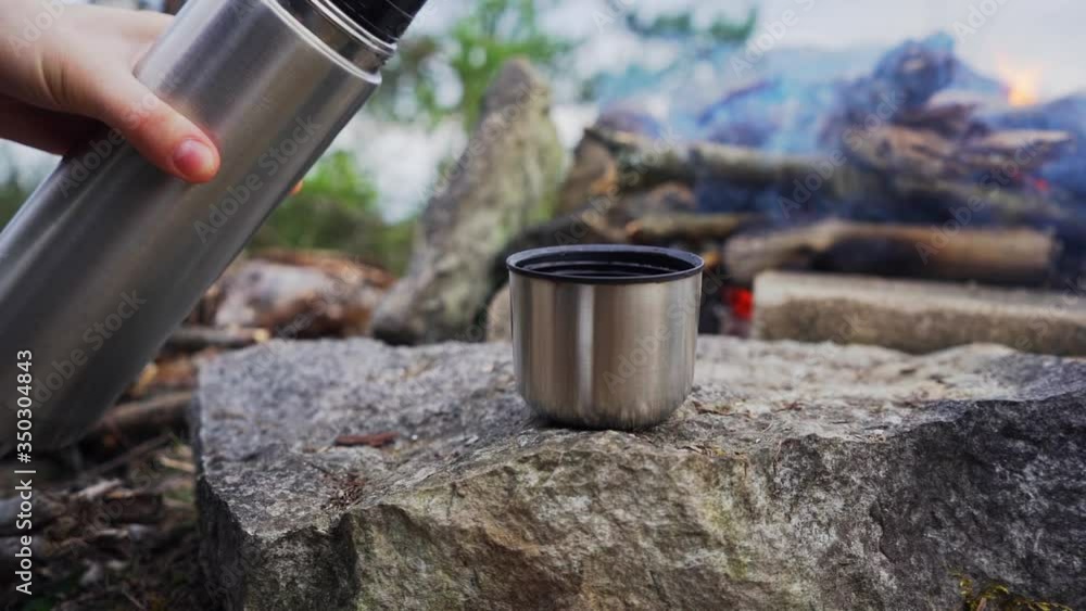 Woman pours water from a thermos flask into a metal mug. Sitting in front of a campfire in the mountains.
Barbecue on the nature in the mountains.
Slow motion footage. Woman pours water from a thermos flask into a metal mug. Sitting in front of a campfire in the mountains.
Barbecue on the nature in the mountains.
Slow motion footage.