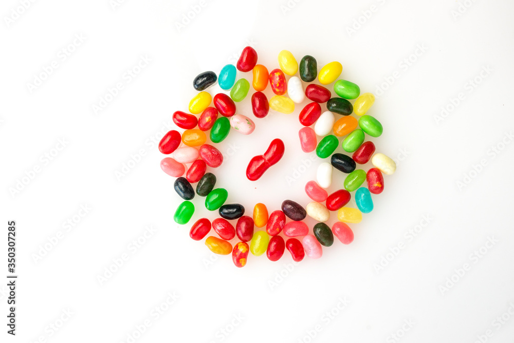 Gang of jellybeans close in or stand to jeer at disabled or deformed jellybean in the middle.