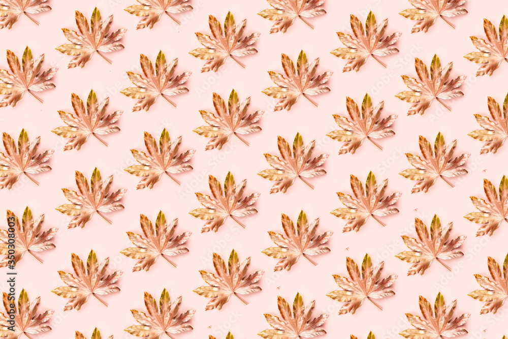 Beautiful Leaf Pattern. Leaves are painted in golden and copper metallic paint on pink background. Autumn minimalism. Isometric flat lay.